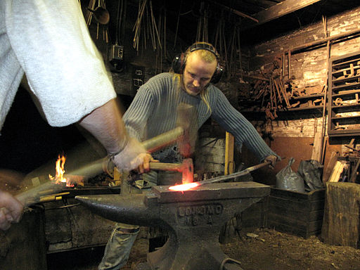 512px-3_tourist_helping_artist_blacksmith_in_finland