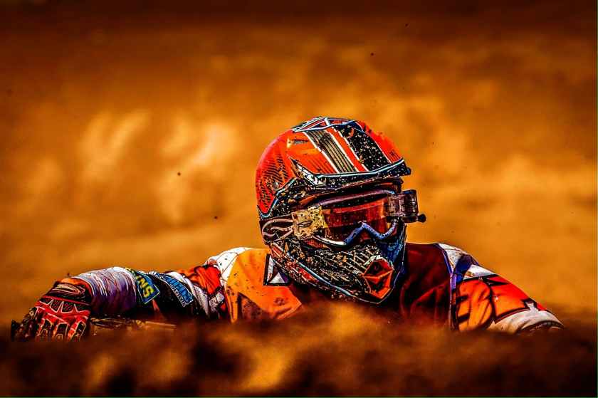 man wearing white black and orange motorcross suit